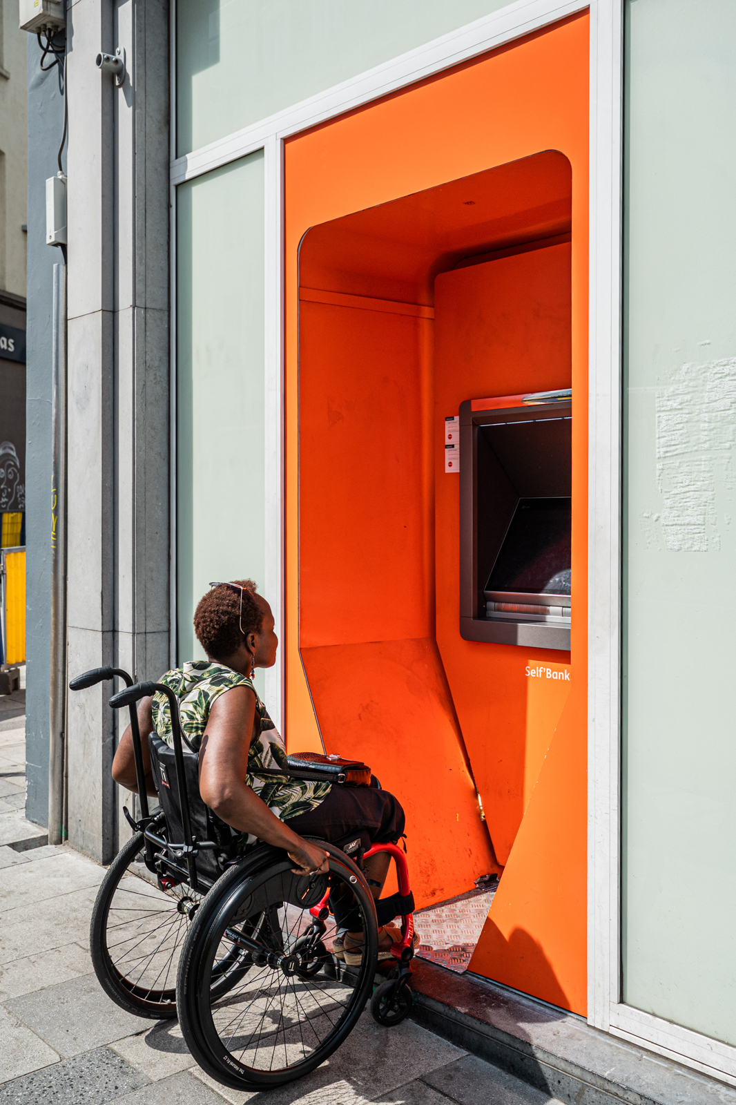 personne en chaise face a un distributeur