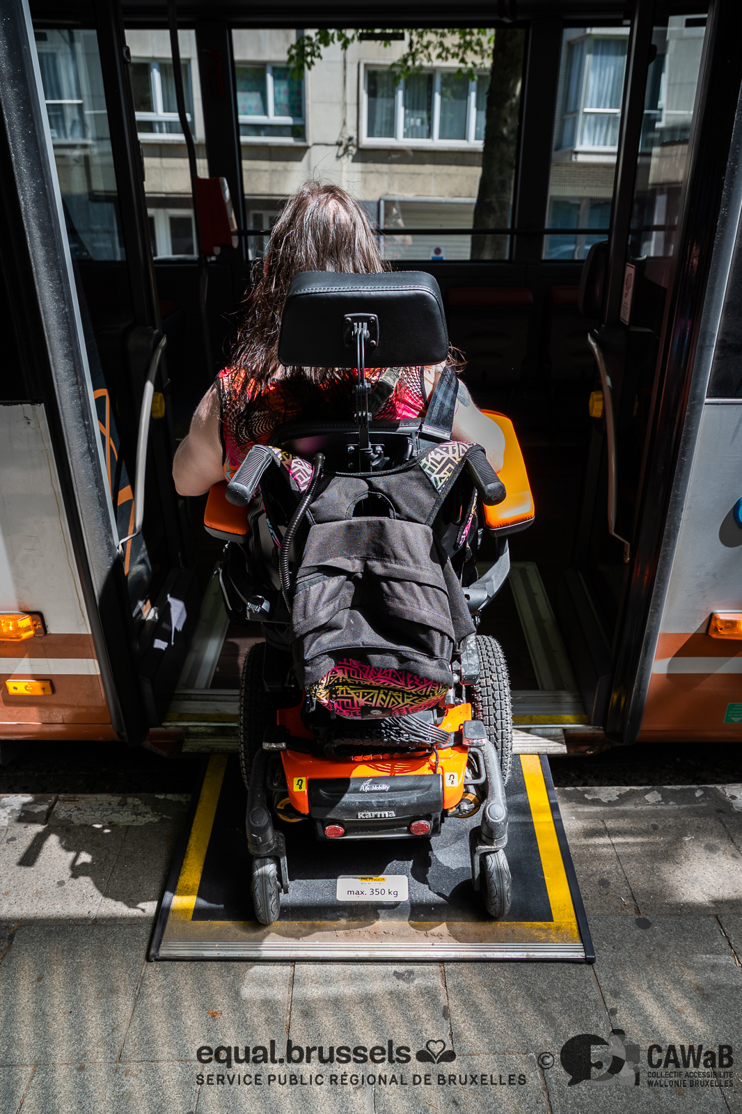 personne en chaise montant dans un bus stib