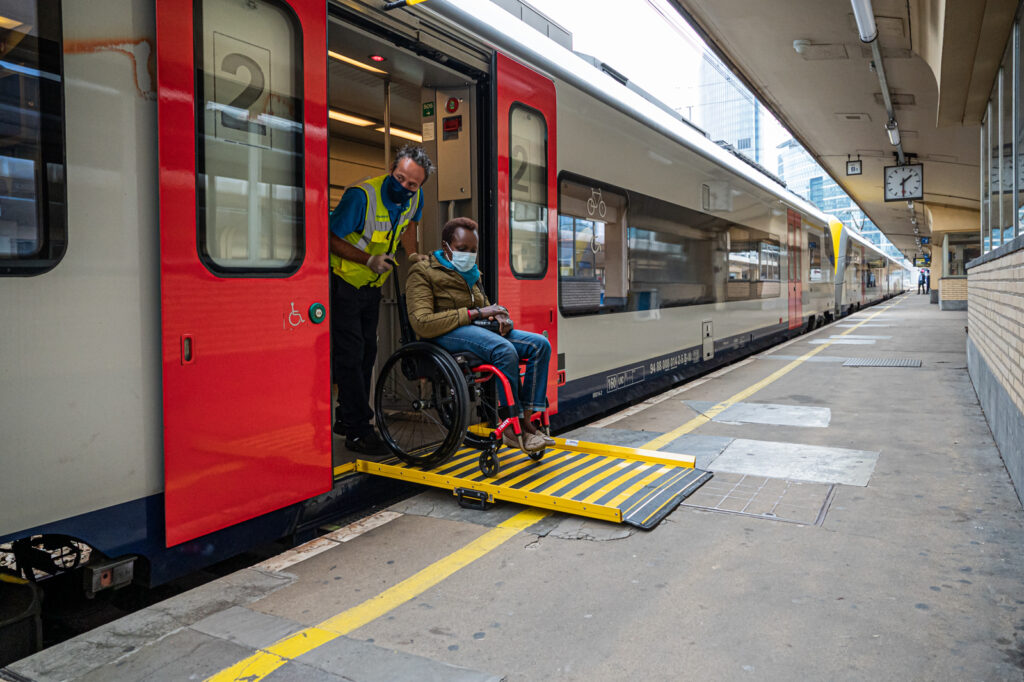 personne en chaise descendant du train via  une rampe